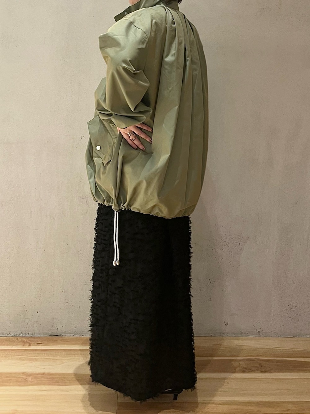 グリーン系のミリタリージャケット、ブラック系のワンピースを着用したレディースの春コーディネートの4枚目の写真