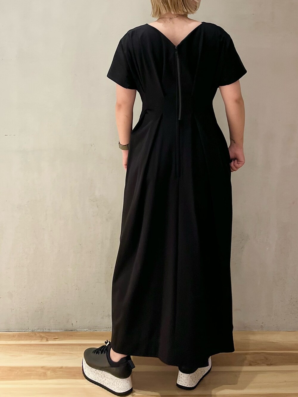 ブラック系のワンピース、ブラック系のスニーカーを着用したレディースの夏コーディネートの2枚目の写真