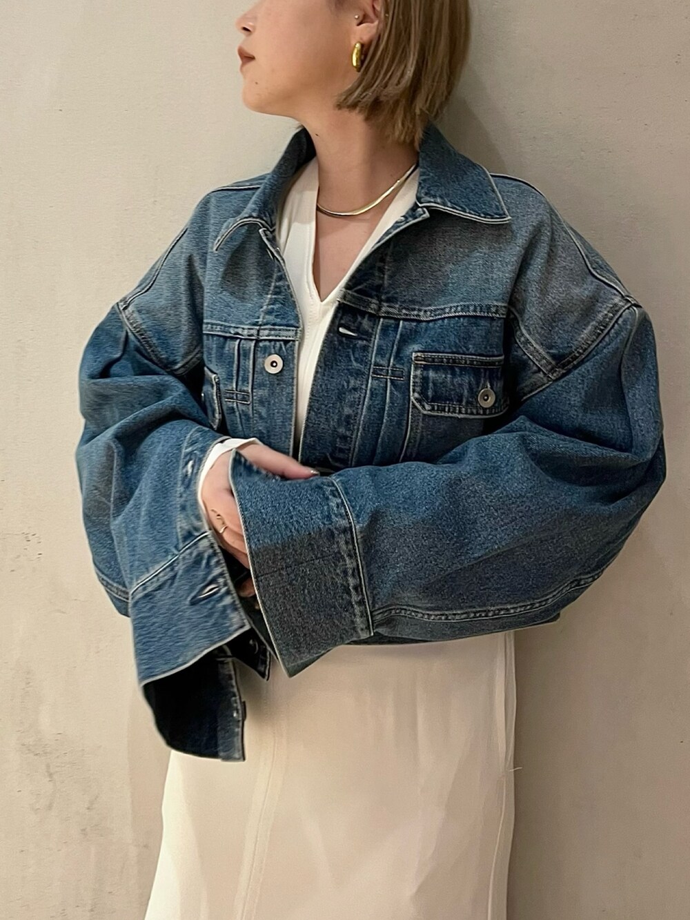 ブルー系のデニムジャケット、ホワイト系のワンピースを着用したレディースの冬コーディネートの5枚目の写真