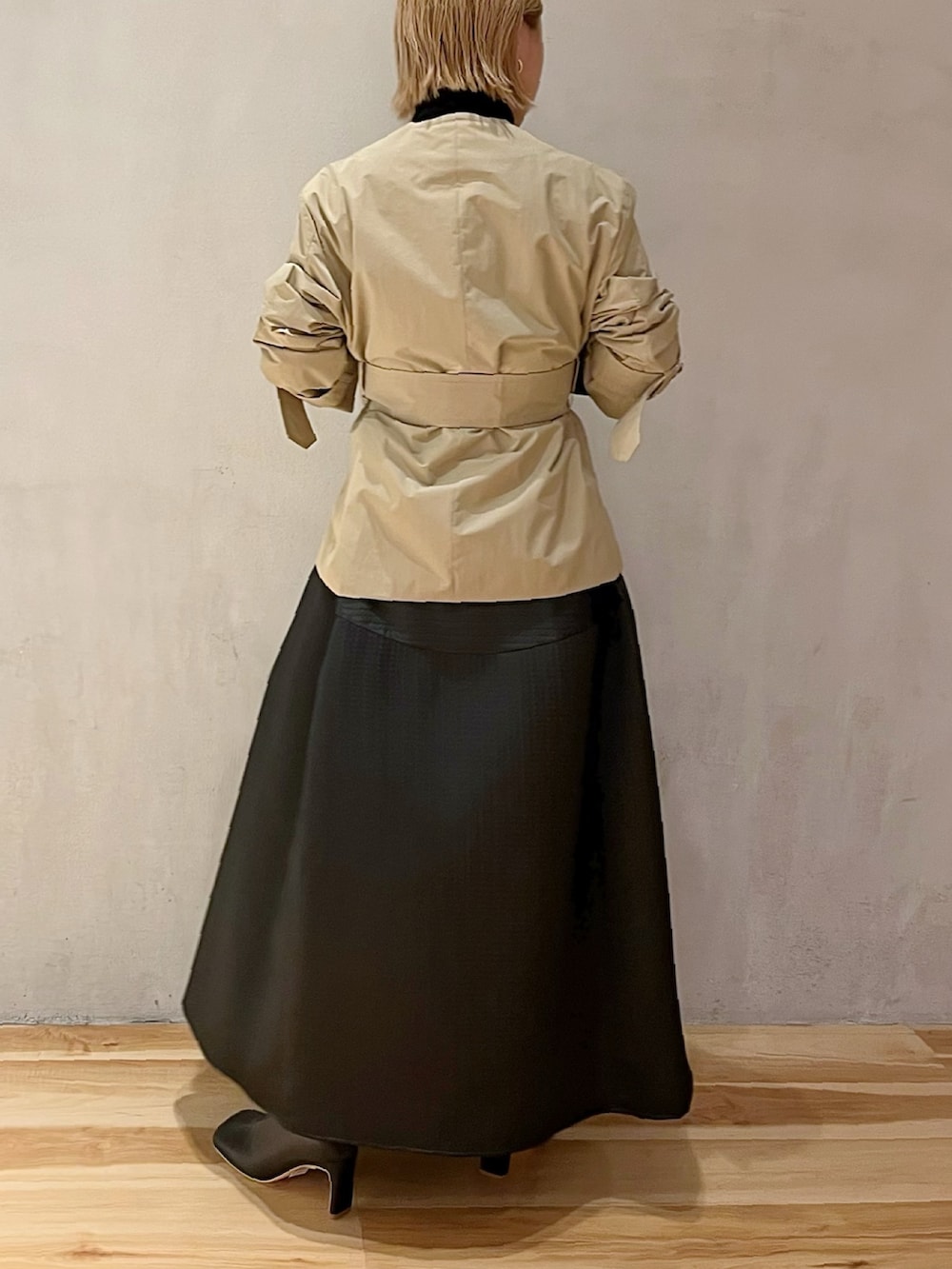 ベージュ系のノーカラージャケット、ブラック系のニット/セーター、ブラック系のスカートを着用したレディースの秋コーディネートの3枚目の写真