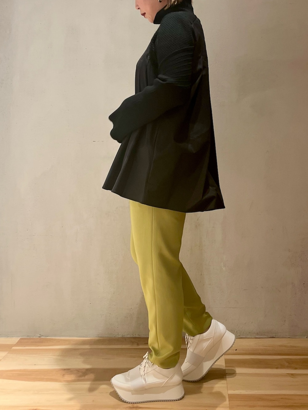 ブラック系のニット/セーター、グリーン系のその他パンツ、ホワイト系のスニーカーを着用したレディースの冬コーディネートの2枚目の写真