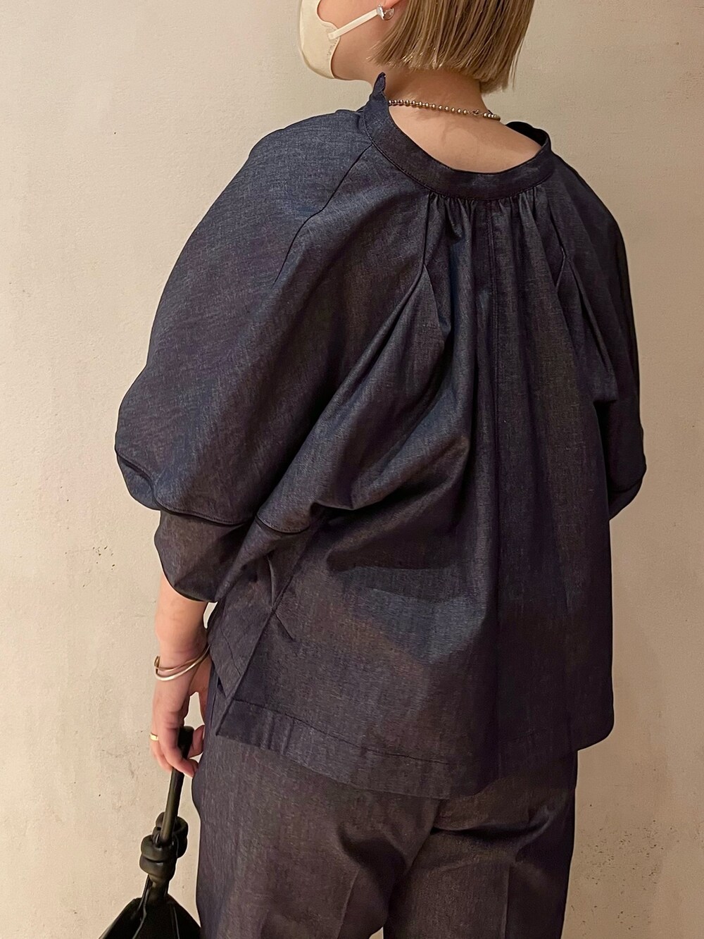 ブラック系のハンドバッグ、ブラック系のサンダル、ブルー系のブルゾンを着用したレディースの春コーディネートの5枚目の写真