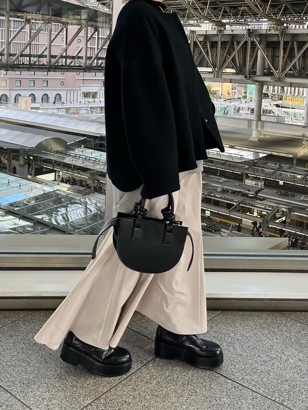 ブラック系のノーカラージャケット、グレー系のワンピース、ブラック系のハンドバッグを着用したレディースの冬コーディネートの2枚目の写真