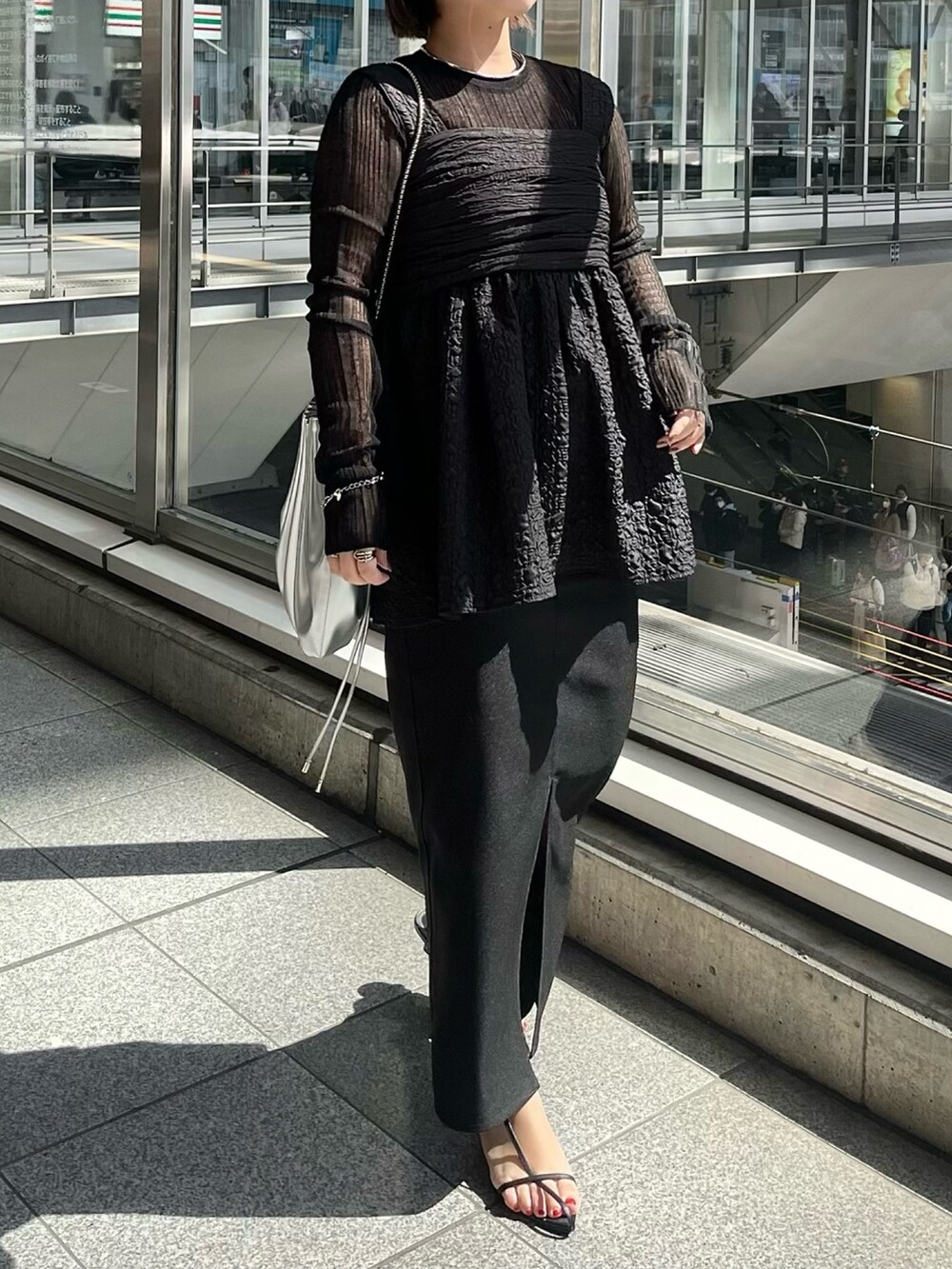 ブラック系のニット/セーター、ブラック系のシャツ/ブラウス、シルバー系のショルダーバッグを着用したレディースの春コーディネートの3枚目の写真