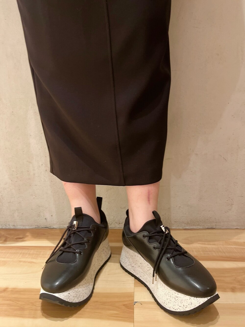 ブラック系のテーラードジャケット、ブラック系のスカート、ブラック系のスニーカーを着用したレディースの冬コーディネートの7枚目の写真