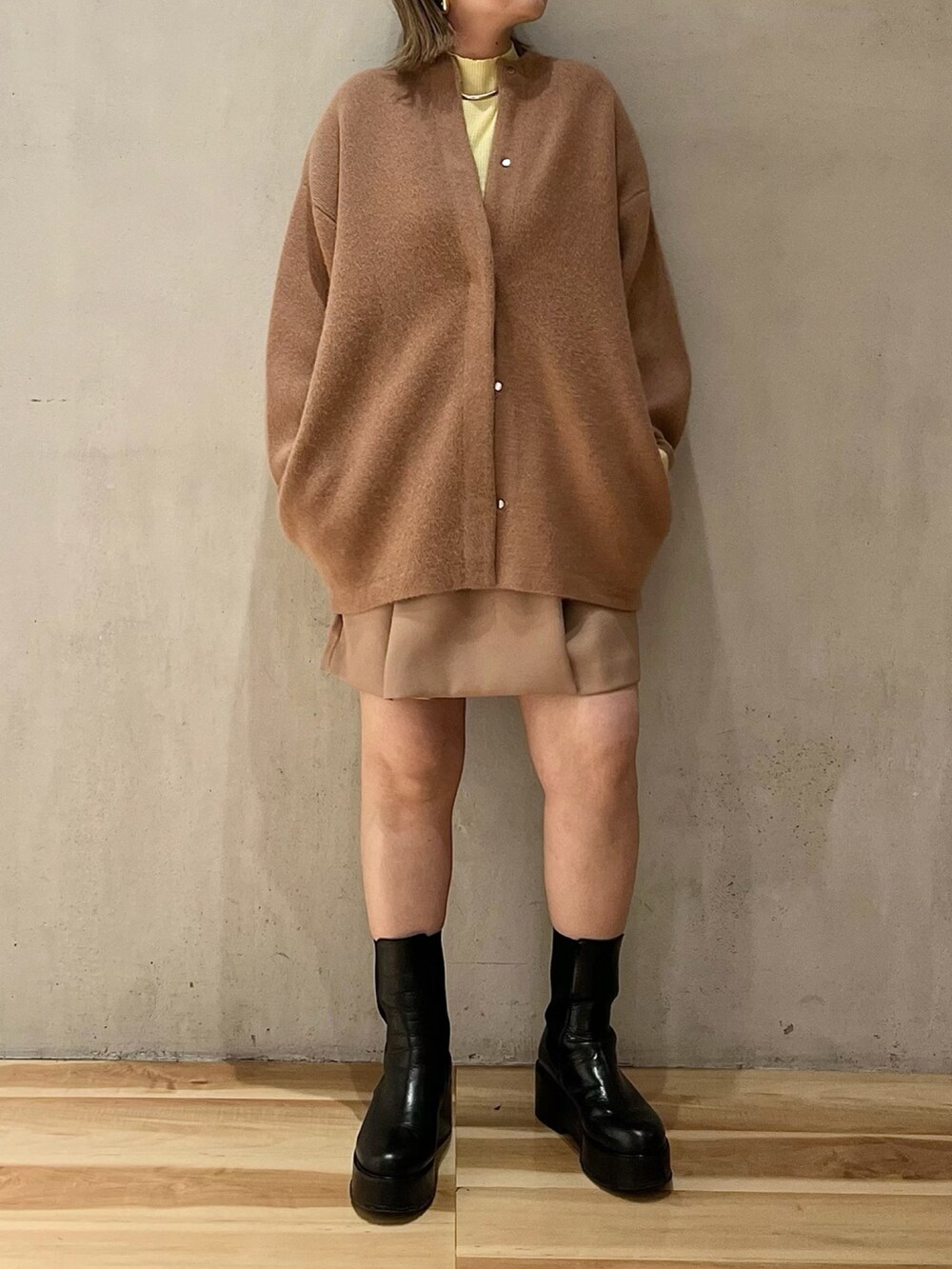 ブラウン系のノーカラージャケット、イエロー系のニット/セーター、ベージュ系のその他パンツを着用したレディースの冬コーディネートの4枚目の写真