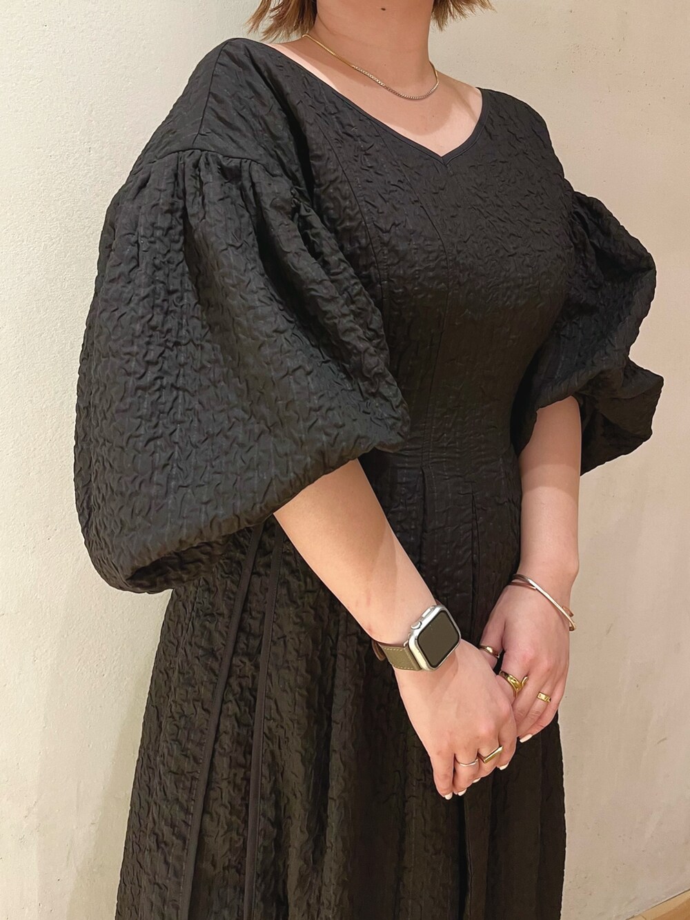 ブラック系のサンダル、ブラック系のワンピース、ゴールド系のネックレスを着用したレディースの冬コーディネートの5枚目の写真