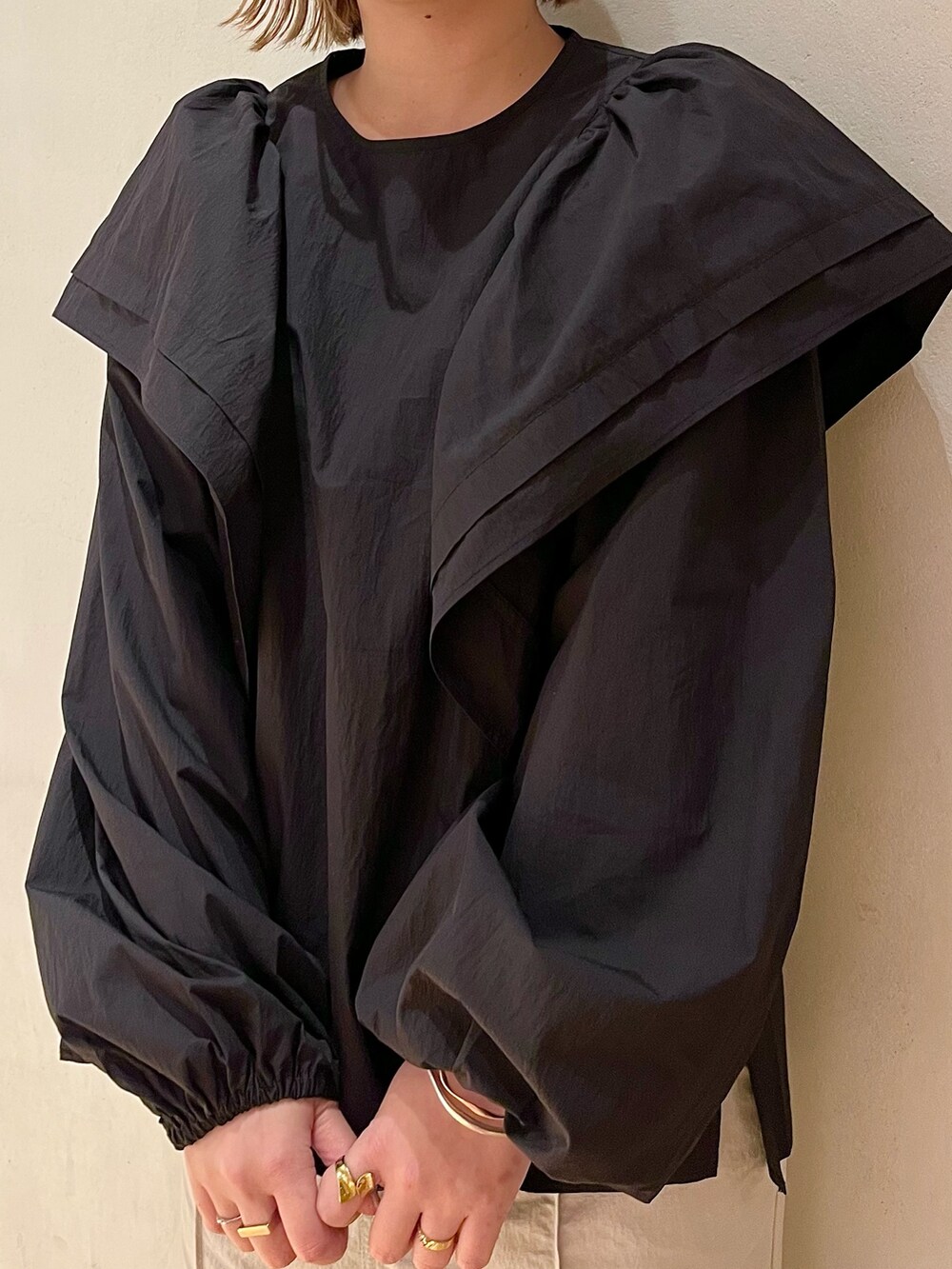 ブラック系のスニーカー、ブラック系のシャツ/ブラウス、ベージュ系のスカートを着用したレディースの冬コーディネートの6枚目の写真