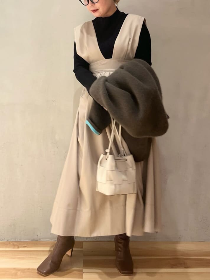 ベージュ系のジャンパースカート、ブラウン系のブーツ、ベージュ系のその他アウターを着用したレディースの秋コーディネートの7枚目の写真