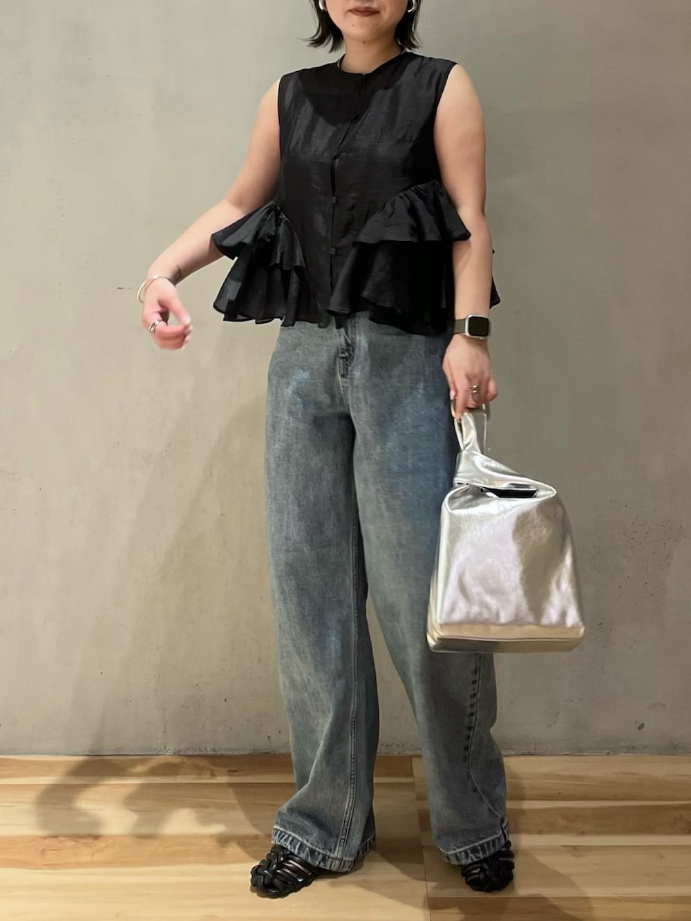 ブラック系のシャツ/ブラウス、ブルー系のデニムパンツ、ブラック系のサンダルを着用したレディースの夏コーディネートの2枚目の写真