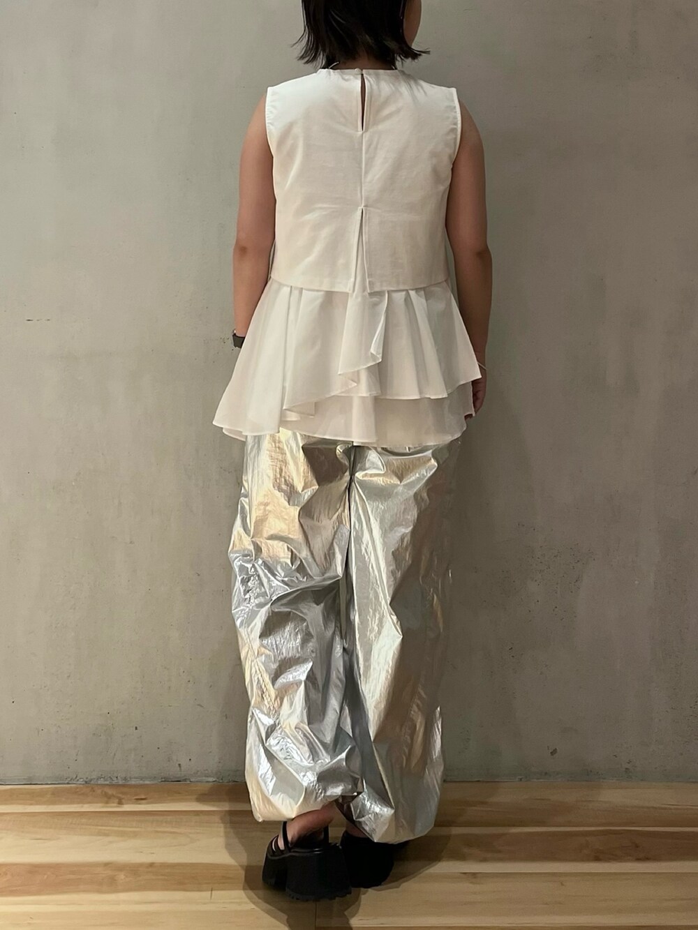 ホワイト系のタンクトップ、シルバー系のその他パンツ、ブラック系のサンダルを着用したレディースの夏コーディネートの3枚目の写真