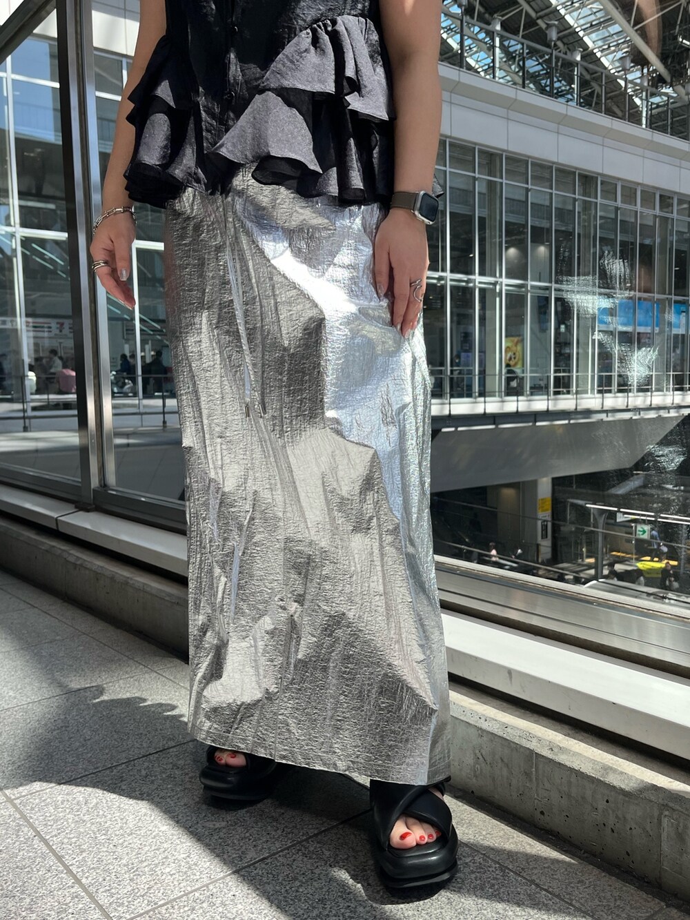 ブラック系のシャツ/ブラウス、シルバー系のスカート、ブラック系のサンダルを着用したレディースの春コーディネートの8枚目の写真