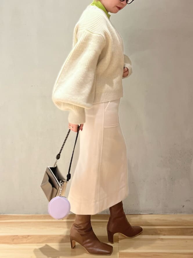 ブラウン系のブーツ、ベージュ系のショルダーバッグ、グリーン系のニット/セーターを着用したレディースの秋コーディネートの2枚目の写真