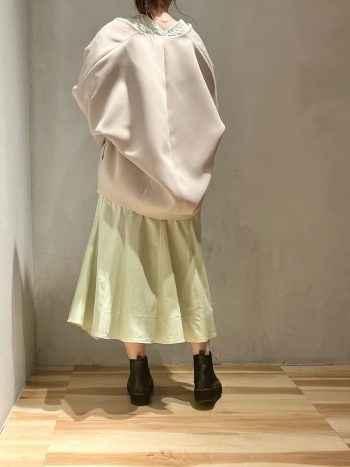 ベージュ系のステンカラーコート、グリーン系のスカート、グリーン系のシャツ/ブラウスを着用したレディースの春コーディネートの4枚目の写真