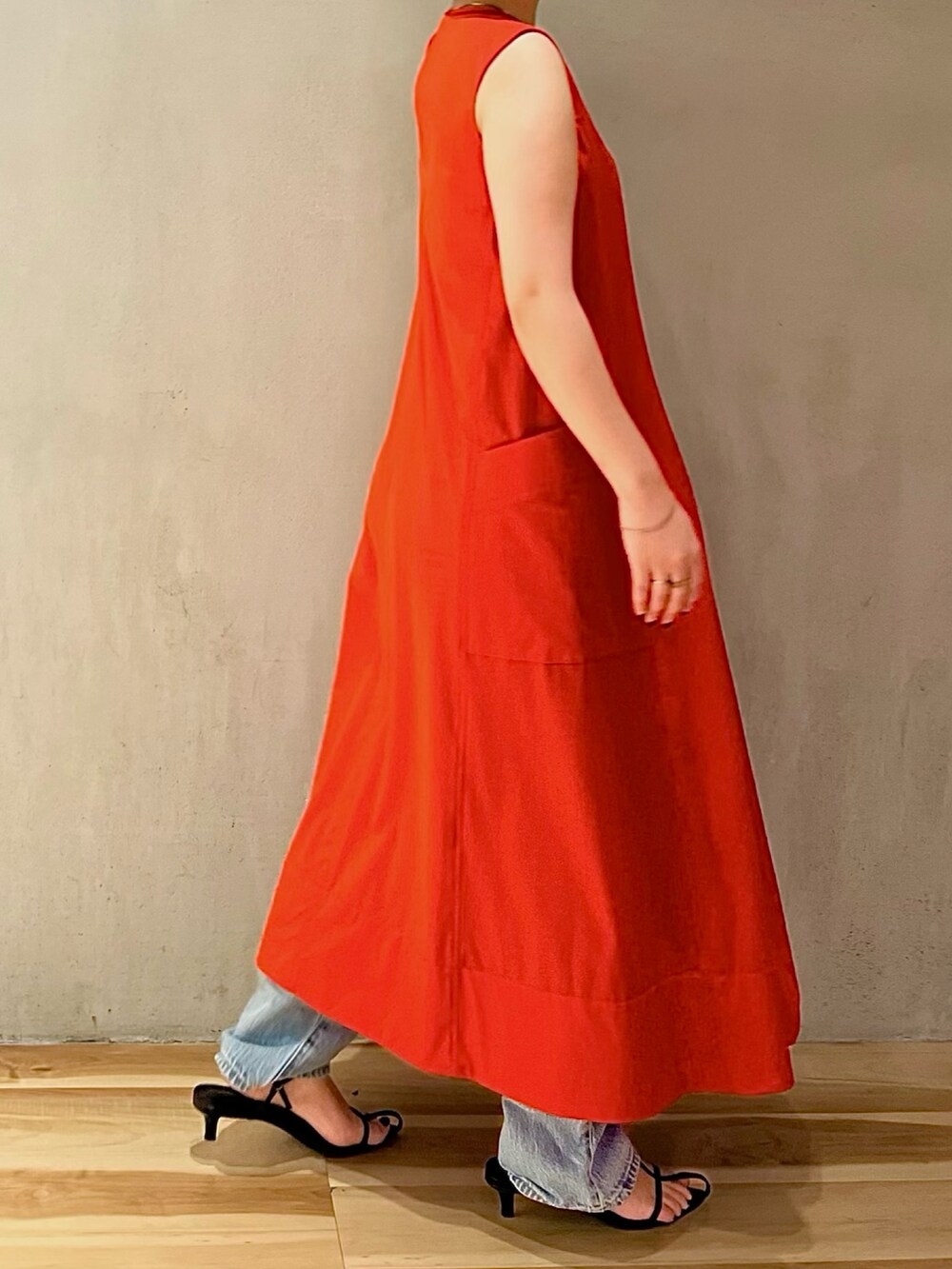 レッド系のワンピース、ホワイト系のハット、ゴールド系のブレスレットを着用したレディースの夏コーディネートの3枚目の写真