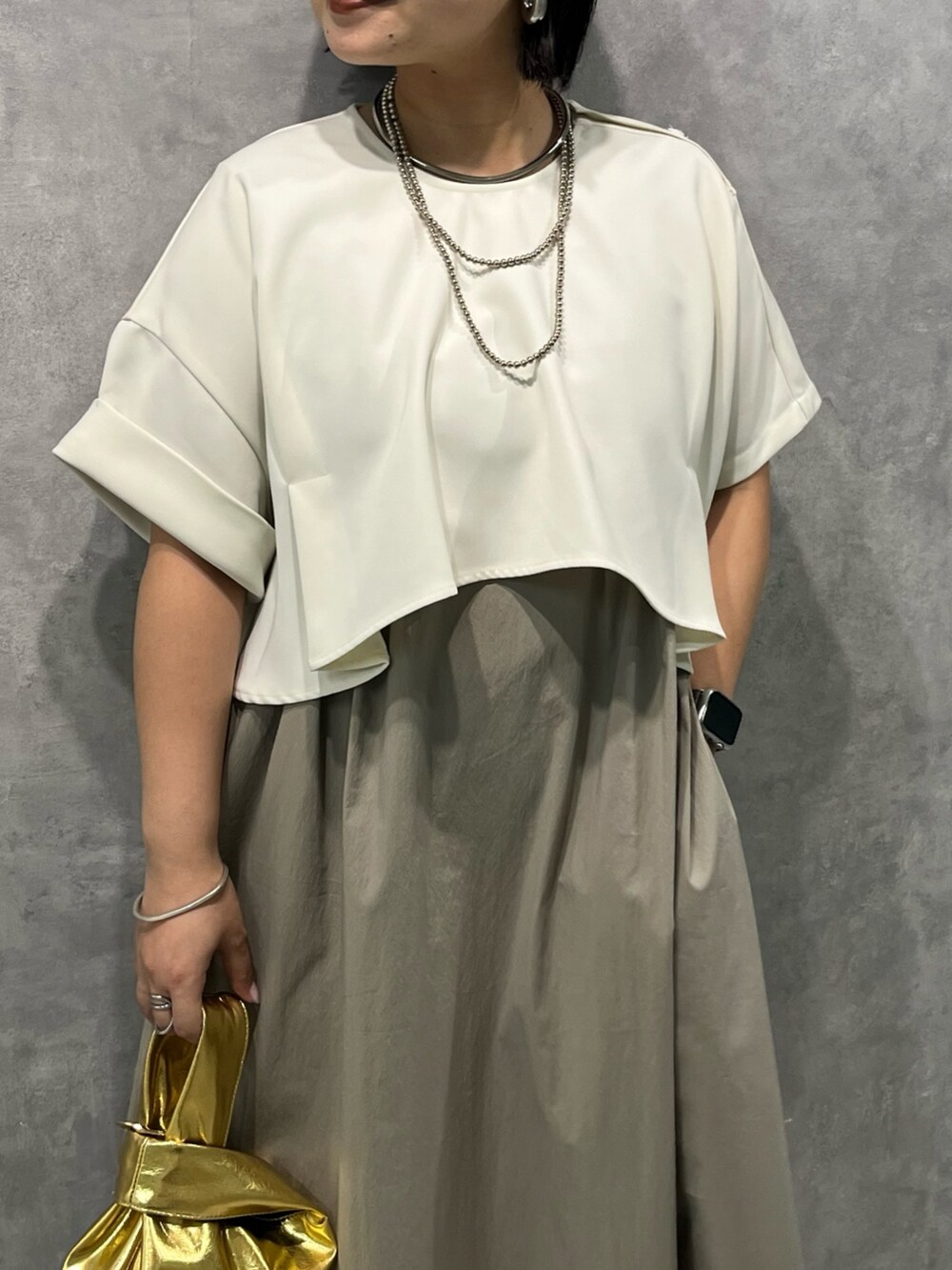 ベージュ系のワンピース、ゴールド系のハンドバッグを着用したレディースの夏コーディネートの5枚目の写真