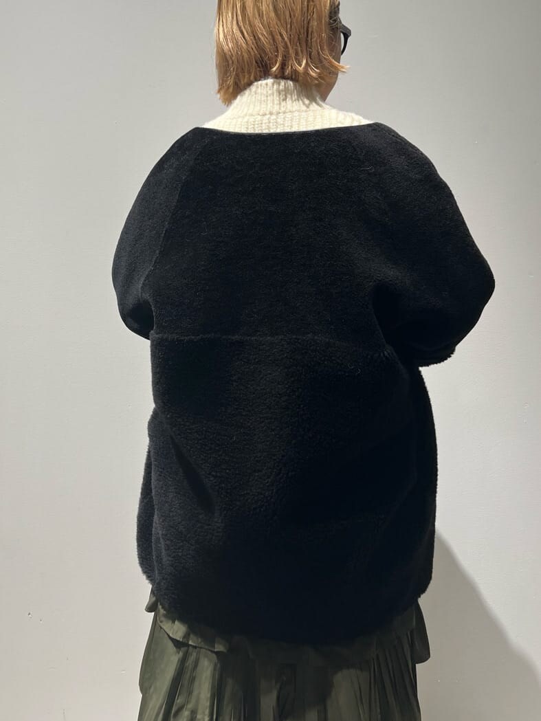 ブラック系のその他アウター、ホワイト系のニット/セーター、グリーン系のスカートを着用したレディースの秋コーディネートの5枚目の写真