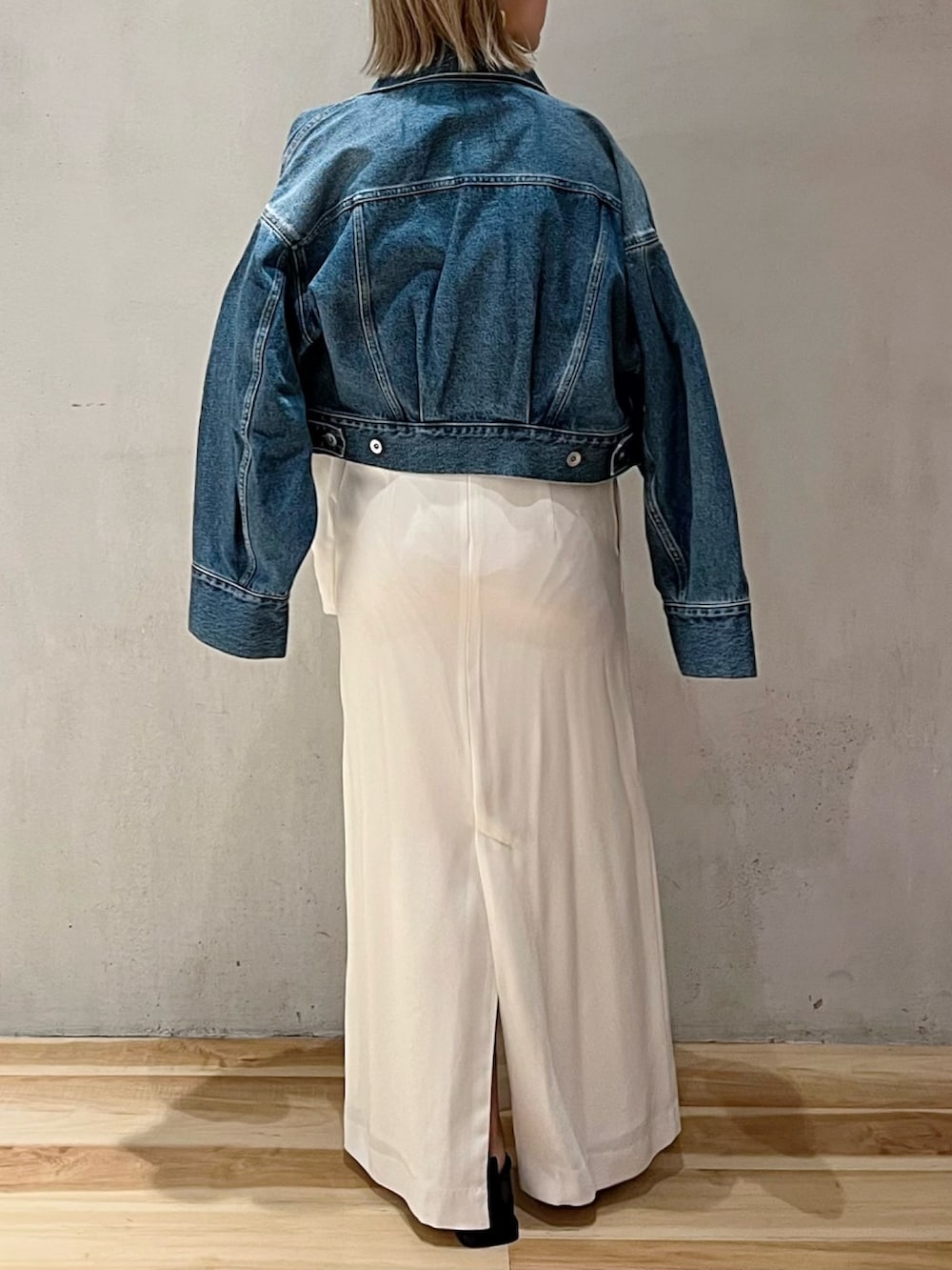 ブルー系のデニムジャケット、ホワイト系のワンピースを着用したレディースの冬コーディネートの3枚目の写真