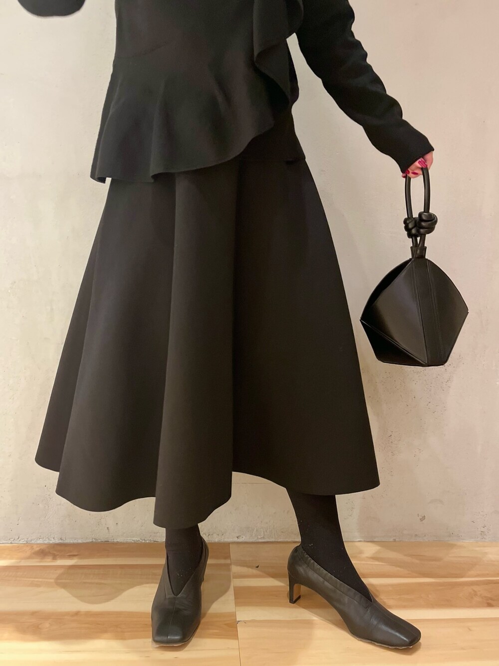 イエロー系のカーディガン/ボレロ、ブラック系のニット/セーター、ブラック系のスカートを着用したレディースの冬コーディネートの8枚目の写真