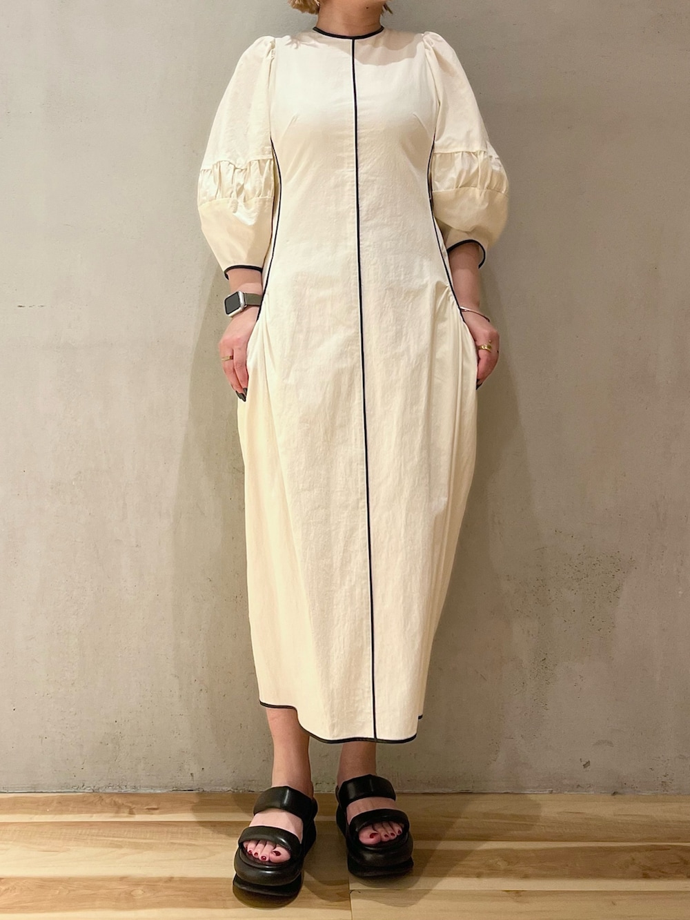 ブラック系のサンダル、ブラック系のブルゾン、ホワイト系のワンピースを着用したレディースの春コーディネートの6枚目の写真