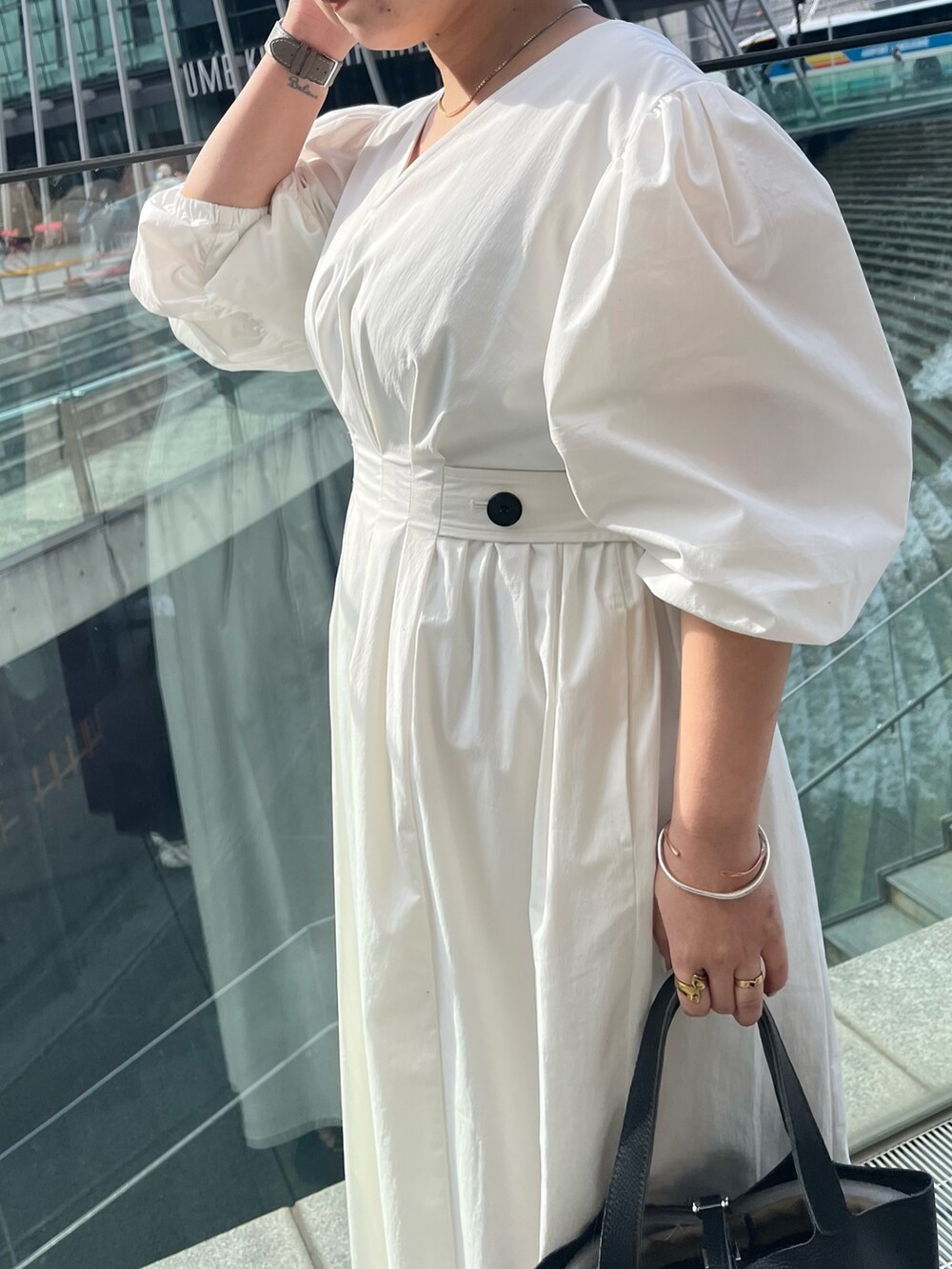 ブラック系のサンダル、ホワイト系のワンピース、ブラック系のハンドバッグを着用したレディースの冬コーディネートの6枚目の写真