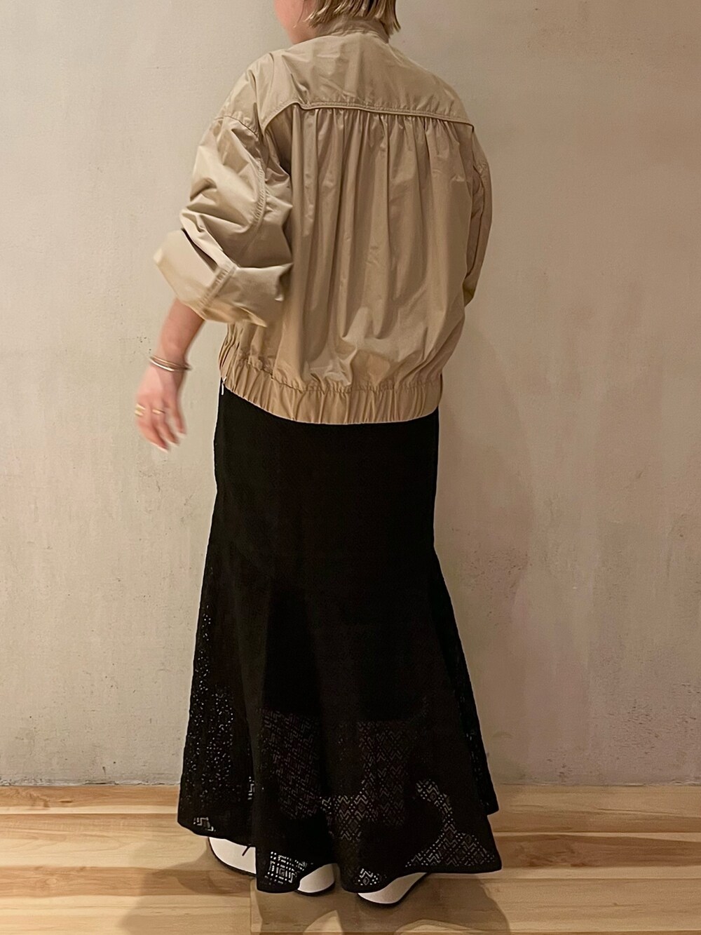 ベージュ系のブルゾン、ブラック系のスニーカー、ブラック系のワンピースを着用したレディースの春コーディネートの3枚目の写真