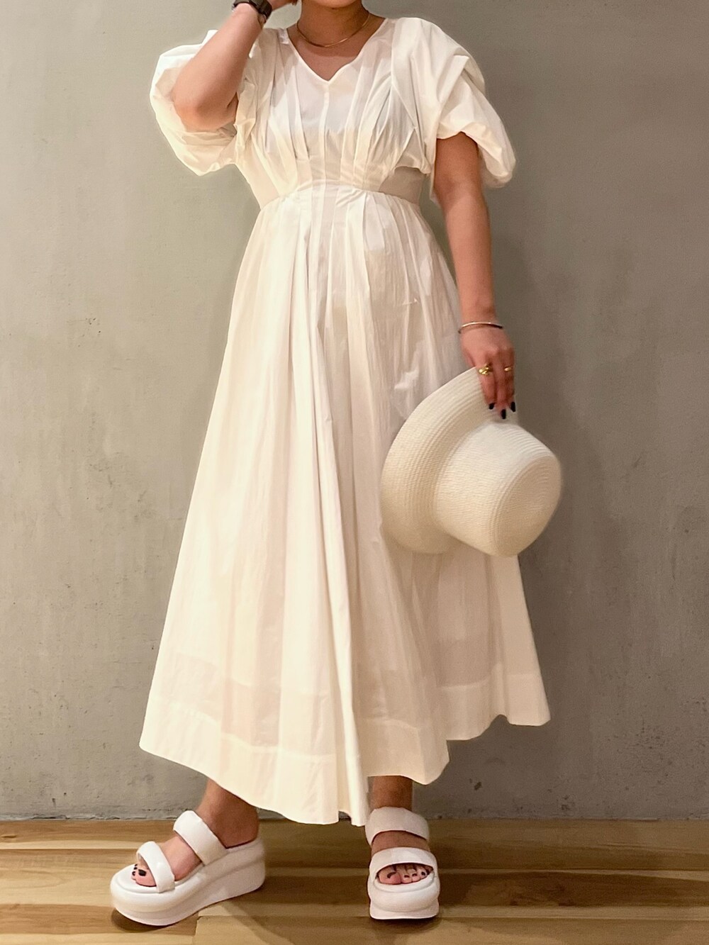 ホワイト系のワンピース、ホワイト系のサンダル、ホワイト系のハットを着用したレディースの春コーディネートの2枚目の写真