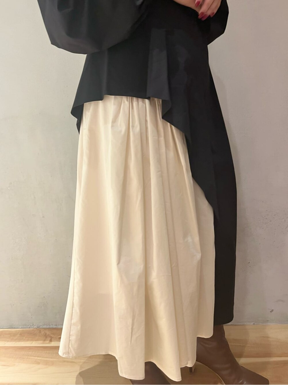 ブラウン系のブーツ、ブラック系のワンピース、イエロー系のノーカラーコートを着用したレディースの秋コーディネートの9枚目の写真