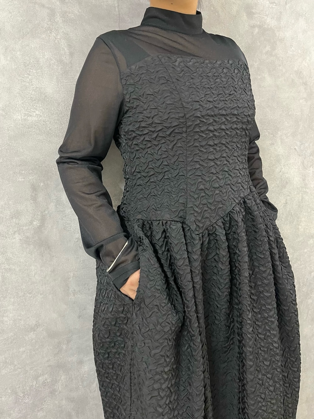 ブラック系のワンピース、ブラック系のブーツを着用したレディースの秋コーディネートの5枚目の写真