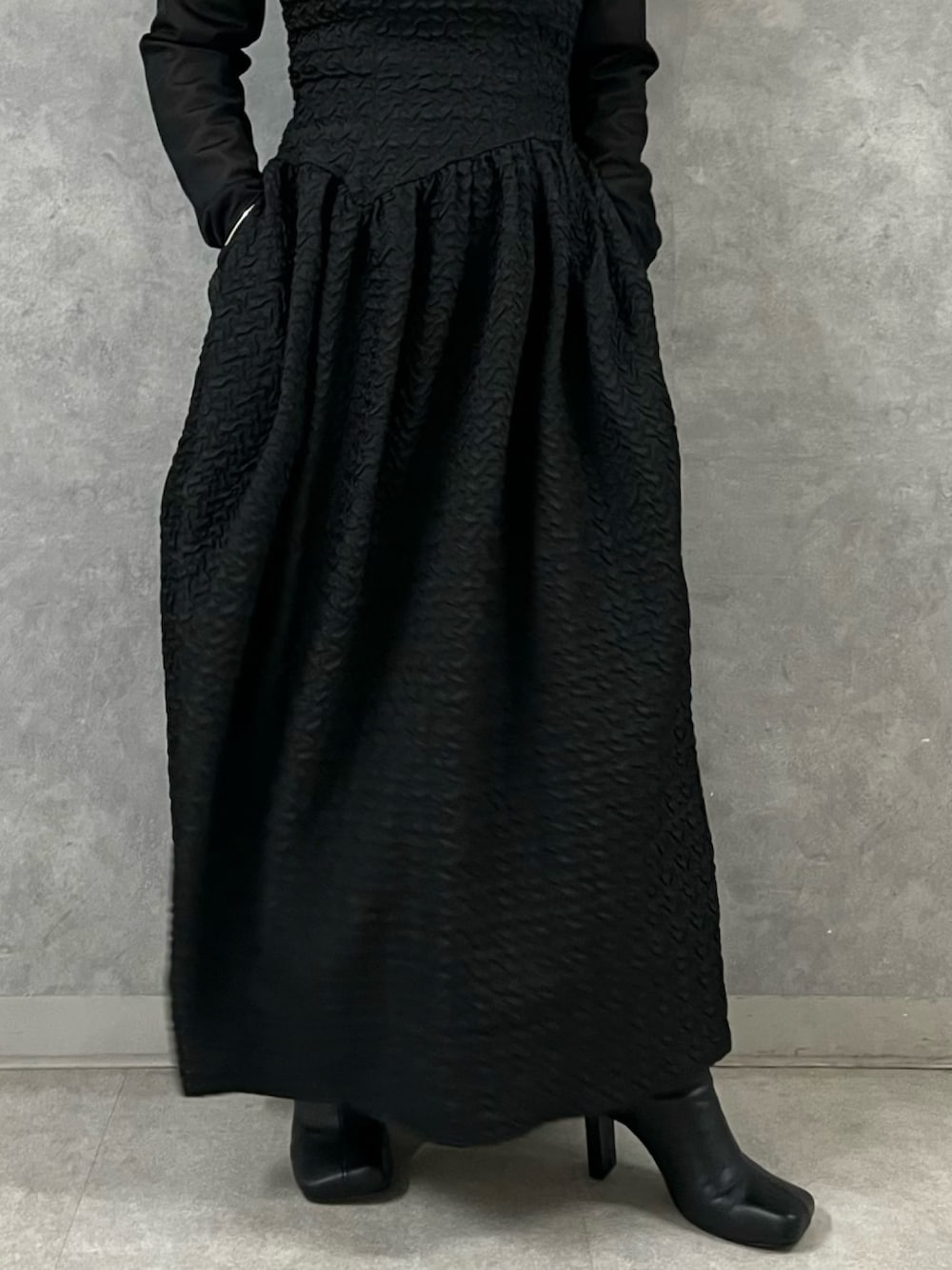 ブラック系のワンピース、ブラック系のブーツを着用したレディースの秋コーディネートの8枚目の写真