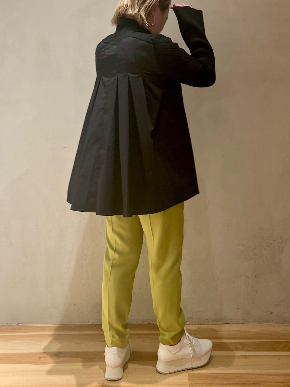 ブラック系のニット/セーター、グリーン系のその他パンツ、ホワイト系のスニーカーを着用したレディースの冬コーディネートの3枚目の写真