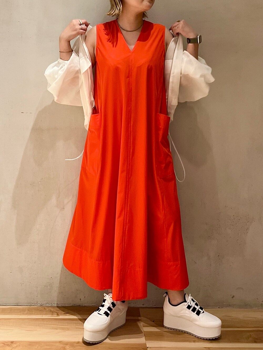 ホワイト系のブルゾン、レッド系のワンピース、ホワイト系のスニーカーを着用したレディースの夏コーディネートの4枚目の写真