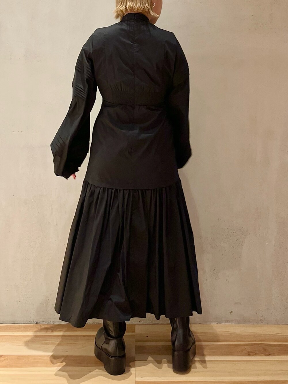 グリーン系のノーカラージャケット、ブラック系のワンピース、ブラック系のブーツを着用したレディースの秋コーディネートの8枚目の写真