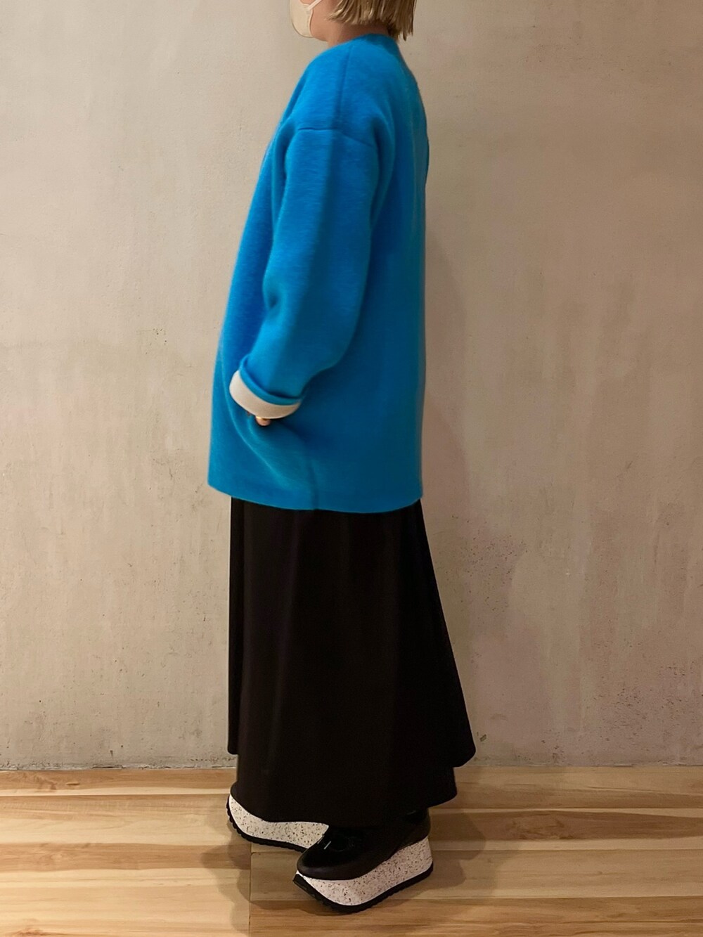 ブルー系のノーカラージャケット、ブラック系のワンピース、ブラック系のスニーカーを着用したレディースの夏コーディネートの3枚目の写真