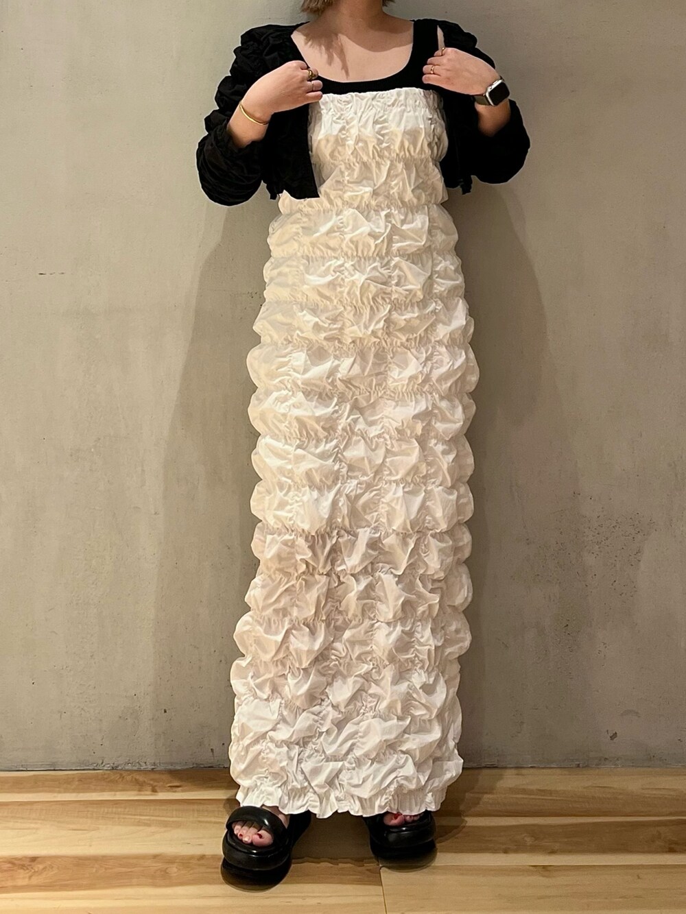 ホワイト系のワンピース、ブラック系のカーディガン/ボレロを着用したレディースの冬コーディネートの4枚目の写真