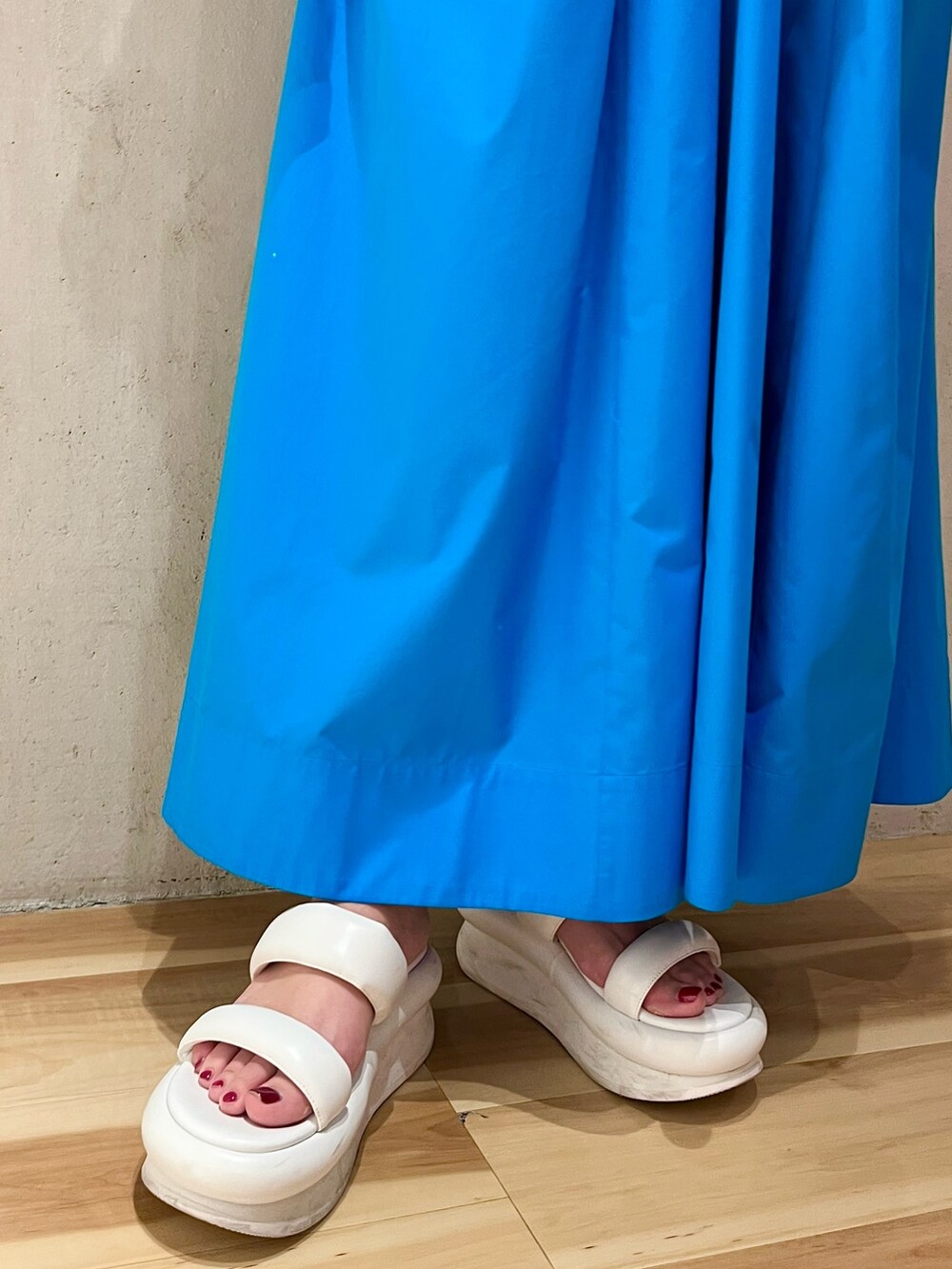 ブルー系のワンピース、ホワイト系のサンダル、ゴールド系のネックレスを着用したレディースの冬コーディネートの8枚目の写真