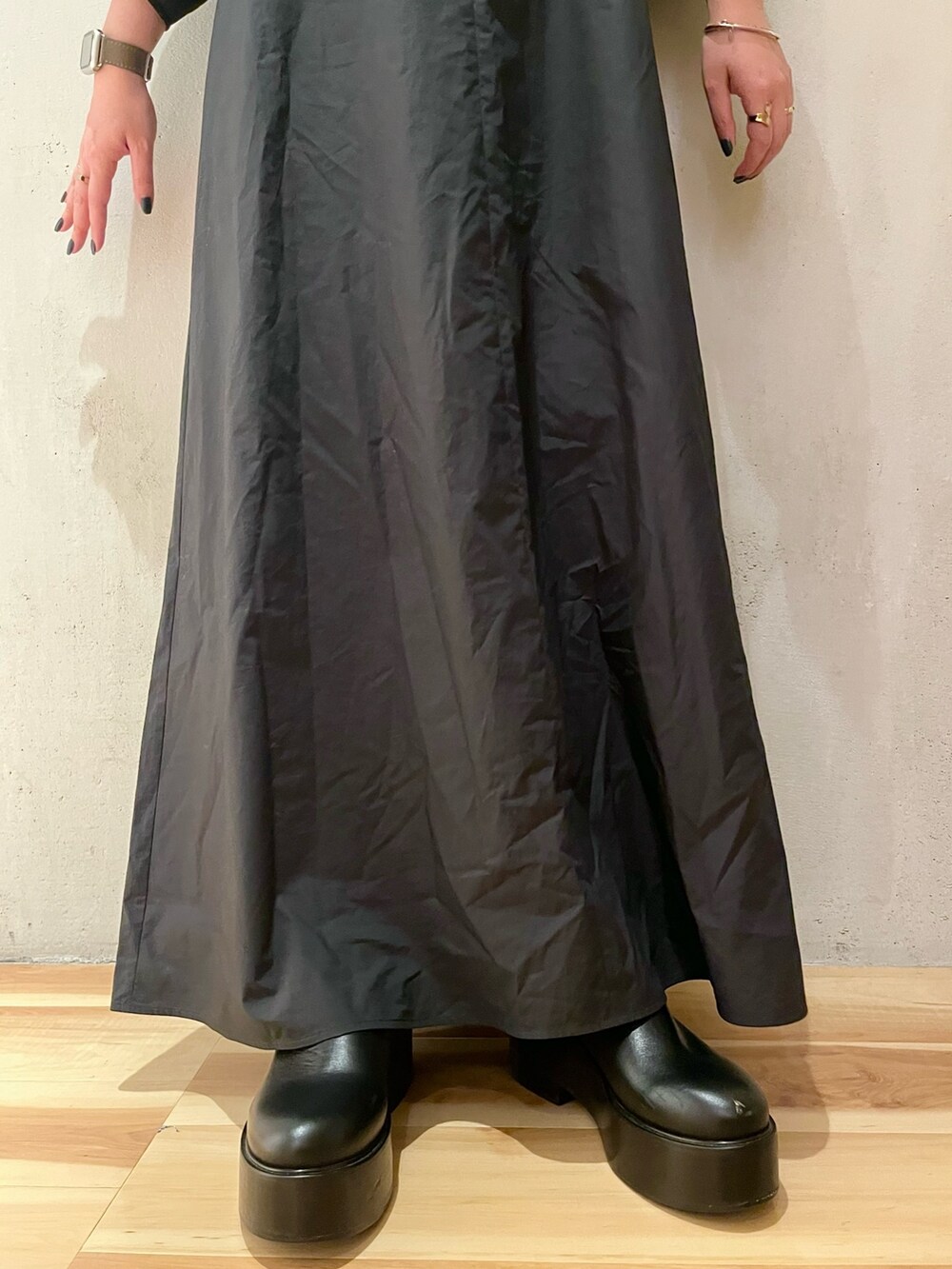 ブラック系のワンピース、ブラック系のブーツを着用したレディースの春コーディネートの6枚目の写真