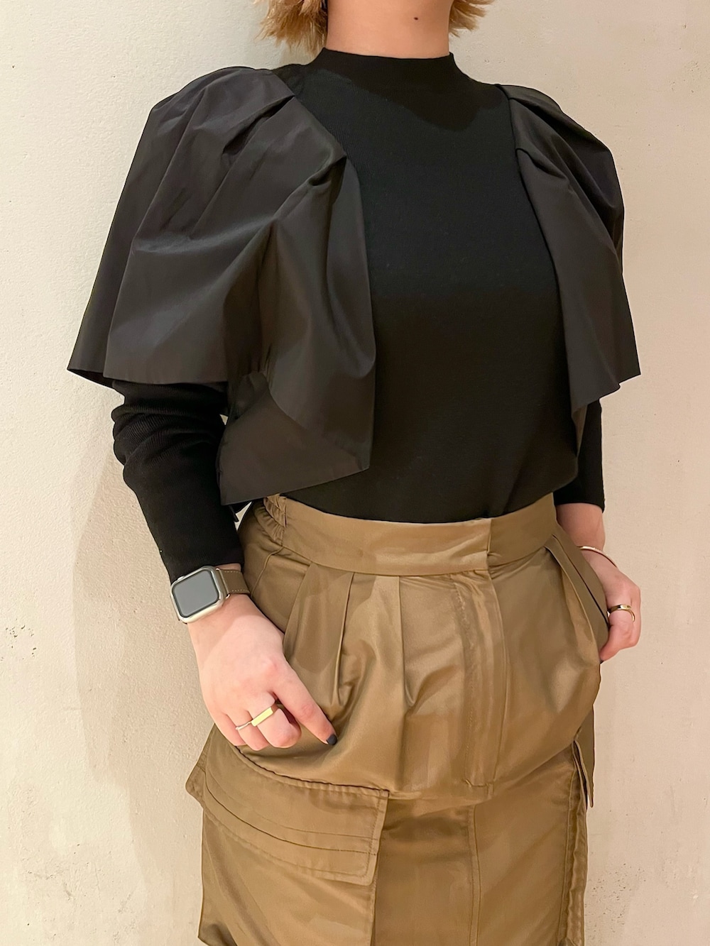 ブラウン系のスカート、ブラック系のブーツ、ブラック系のニット/セーターを着用したレディースの春コーディネートの8枚目の写真