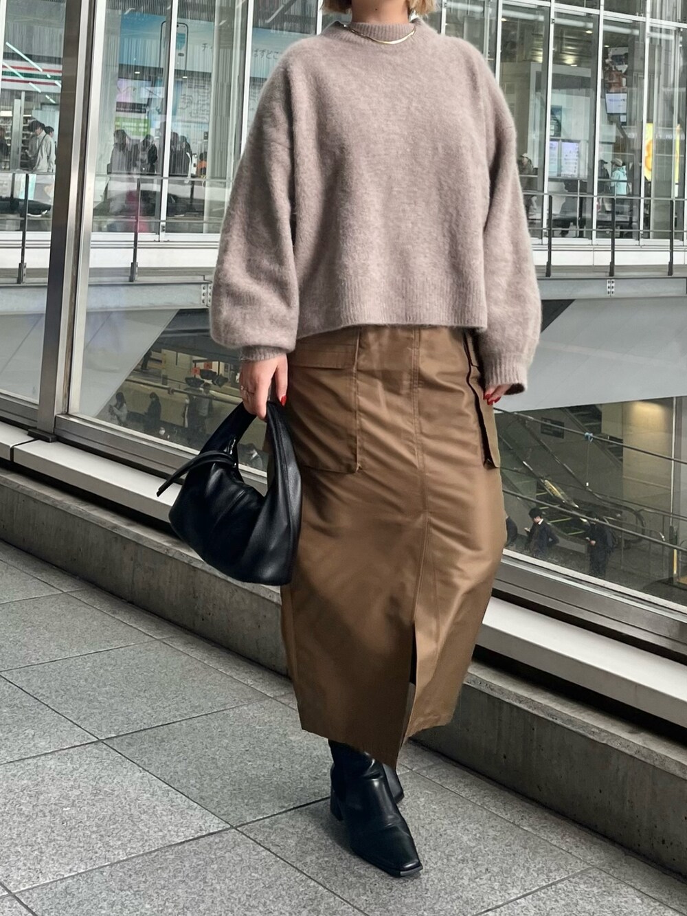 ベージュ系のニット/セーター、ブラウン系のスカートを着用したレディースの秋コーディネートの4枚目の写真