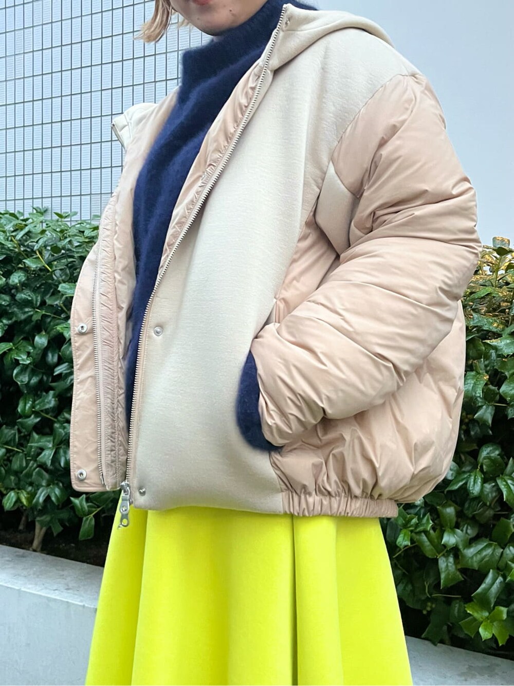 ベージュ系のダウンジャケット/コート、ブルー系のニット/セーター、イエロー系のスカートを着用したレディースの秋コーディネートの4枚目の写真