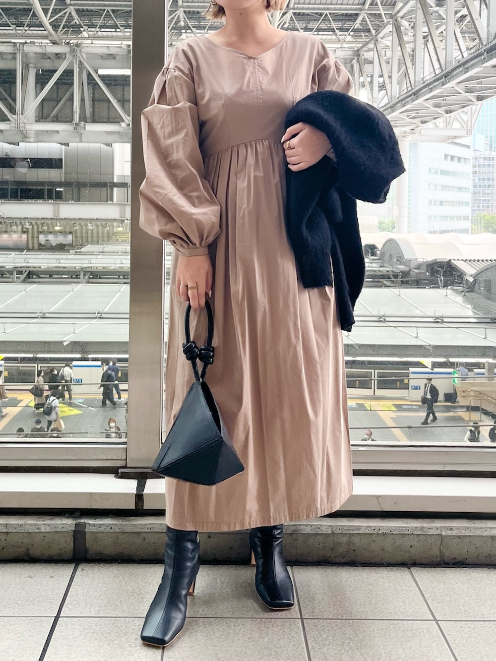 ブラック系のワンピース、ブラック系のハンドバッグ、ブラック系のブーツを着用したレディースの秋コーディネートの8枚目の写真