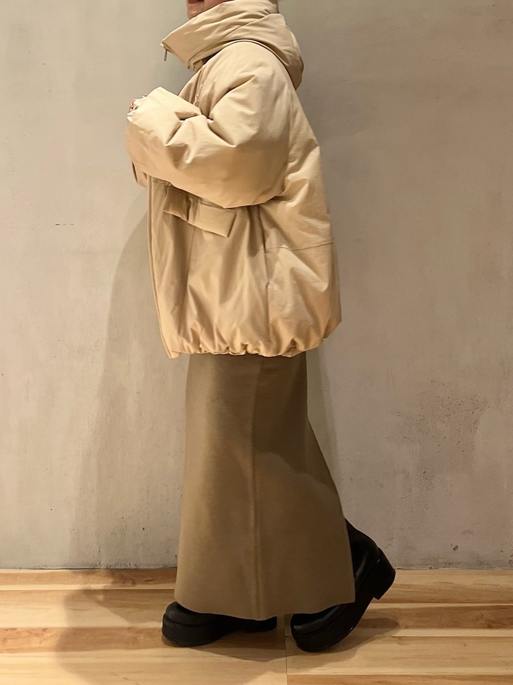 ベージュ系のダウンジャケット/コート、ベージュ系のスカート、ベージュ系のニット/セーターを着用したレディースの冬コーディネートの5枚目の写真