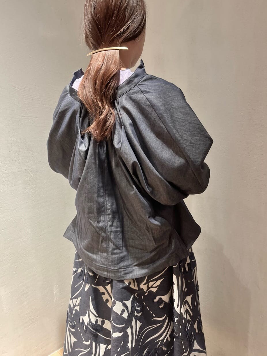 パープル系のニット/セーター、ブルー系のスカート、ブルー系のシャツ/ブラウスを着用したレディースの春コーディネートの4枚目の写真