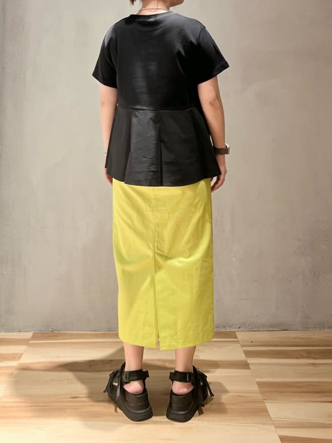 ブラック系のサンダル、イエロー系のスカート、ブラック系のTシャツ/カットソーを着用したレディースの夏コーディネートの2枚目の写真