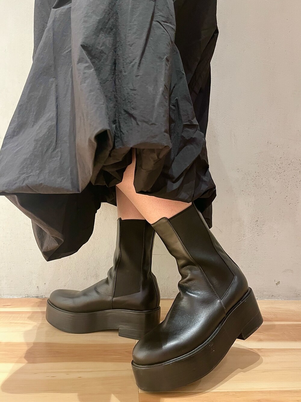 ブラック系のワンピース、ブラック系のブーツを着用したレディースの春コーディネートの9枚目の写真