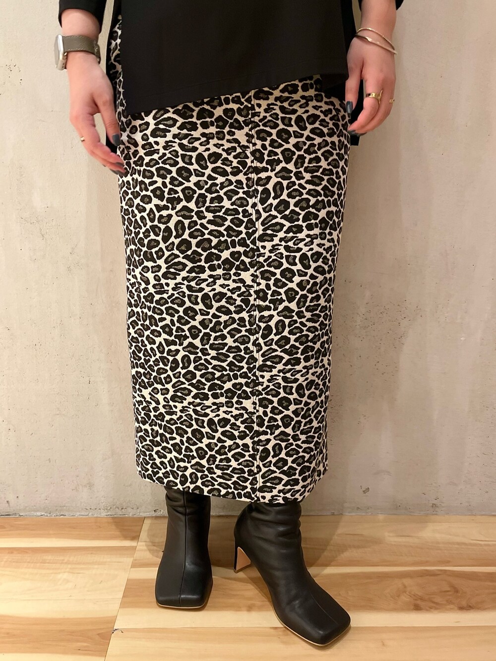 ブラック系のTシャツ/カットソー、ホワイト系のスカート、ブラック系のブーツを着用したレディースの春コーディネートの9枚目の写真