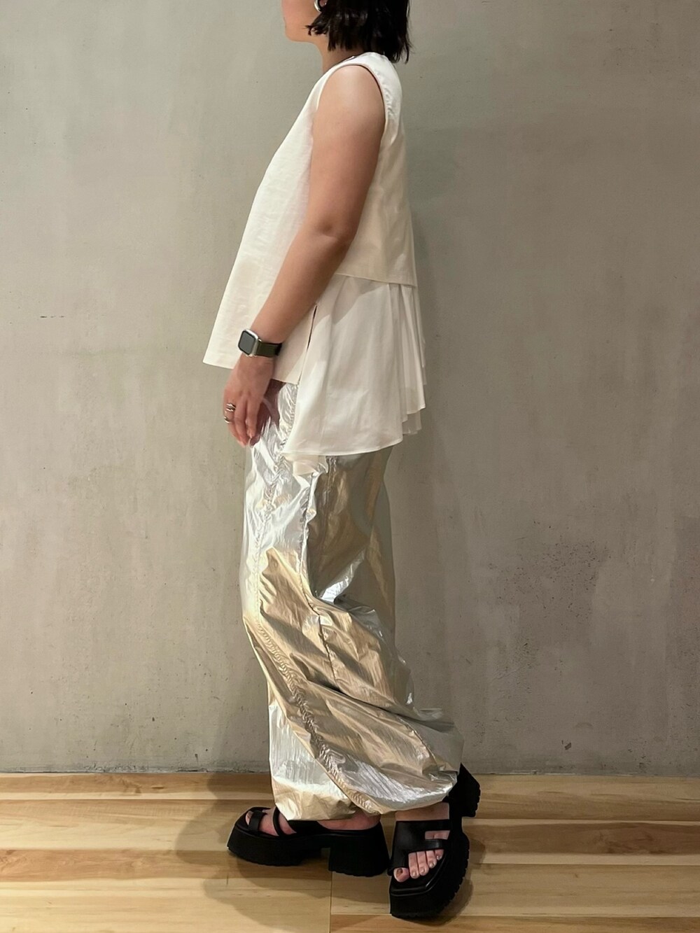 ホワイト系のタンクトップ、シルバー系のその他パンツ、ブラック系のサンダルを着用したレディースの夏コーディネートの2枚目の写真