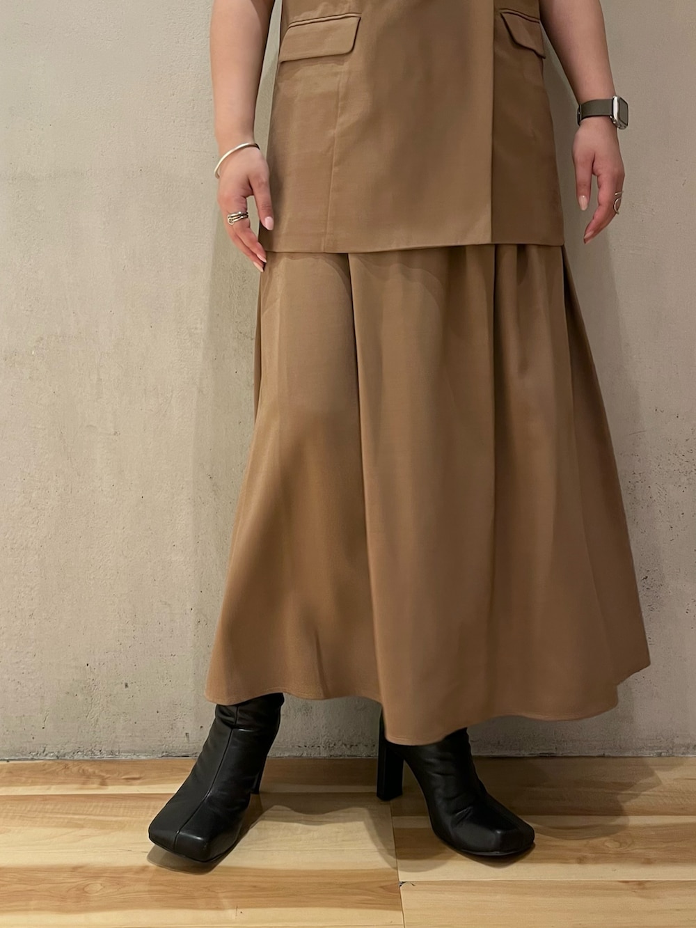 ベージュ系のワンピース、ブラック系のブーツ、ブラック系のキャップを着用したレディースの夏コーディネートの8枚目の写真