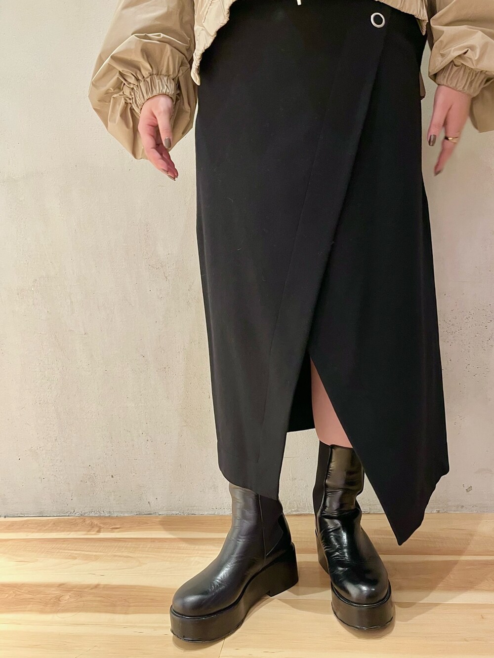 ベージュ系のブルゾン、ブラック系のスカート、ブラック系のブーツを着用したレディースの秋コーディネートの7枚目の写真