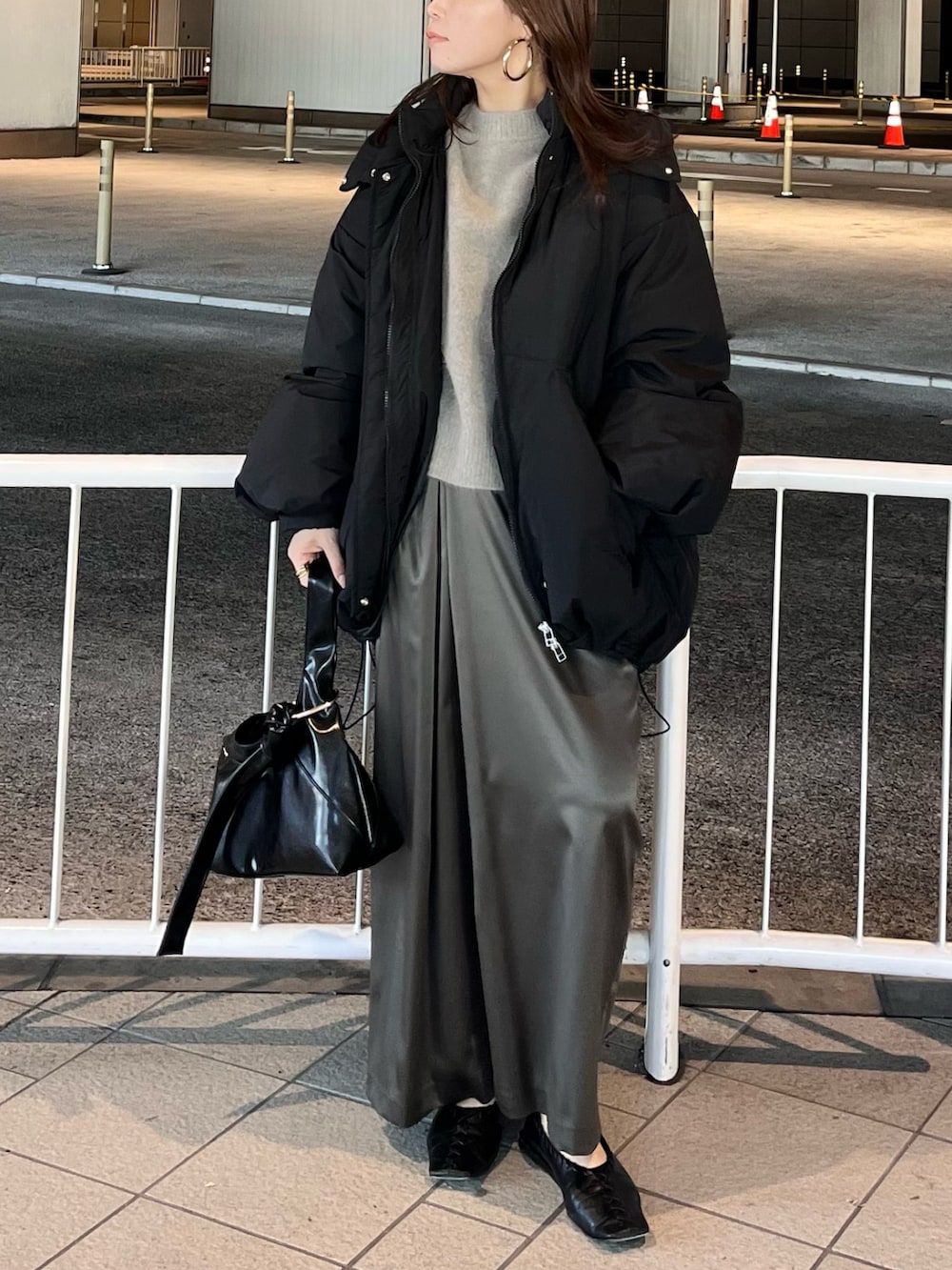 ブラック系のダウンジャケット/コート、ブラウン系のニット/セーター、ブラウン系のスカートを着用したレディースの冬コーディネートの3枚目の写真